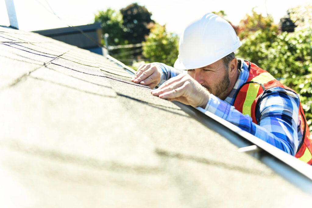 Roofer inspecting an aging roof